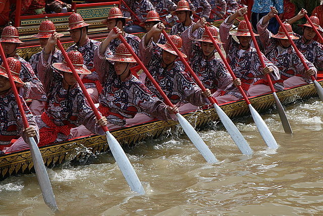 Thai Traditional Barge With Men Rowing Down The Bangkok Chao Phraya River