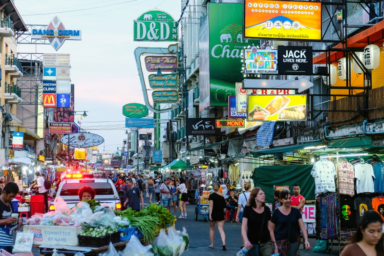 Tourists And Locals Walking Along The Busy Streets Of Khao San Road In Bangkok