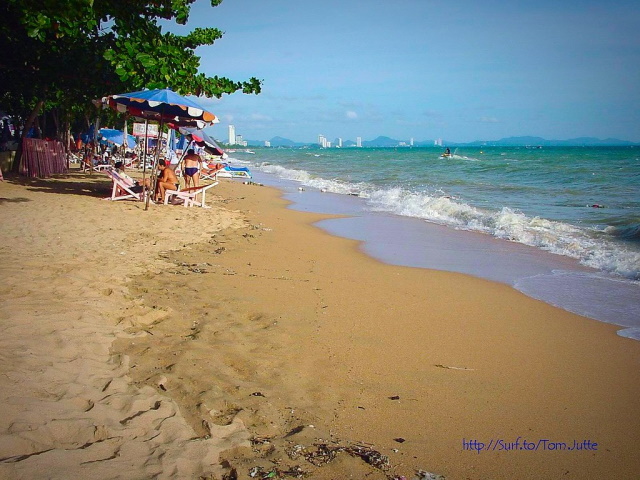 Jomtien Beach With People And Deck Chairs In The Background