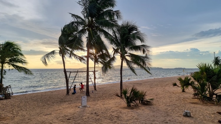 Dongtan Beach Pattaya Palm Trees On The Beach During Sunset With Kids Playing On A Swing