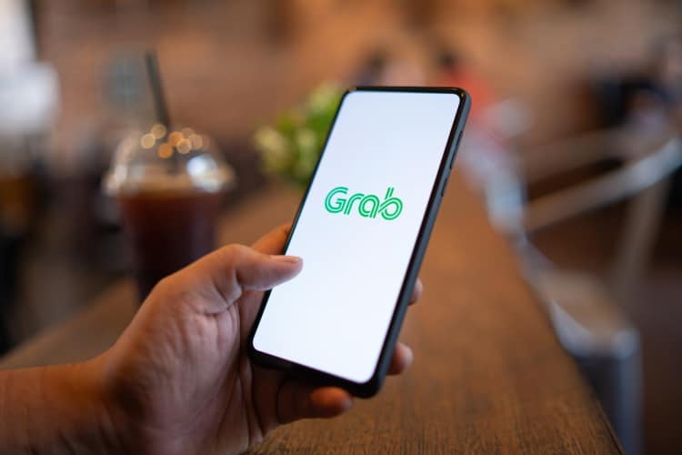 Grab App Being Used On Mobile Phone In Cafe