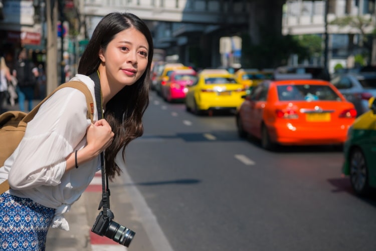 Asian Woman Hailing A Taxi In Bangkok Thailand