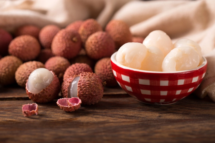 Lychee Fruit With Some Opened In A Bowl On A Wooden Table