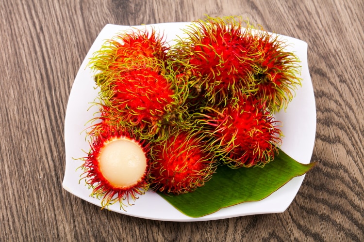 Rambutan Fruit On A White Plate And Wooden Table