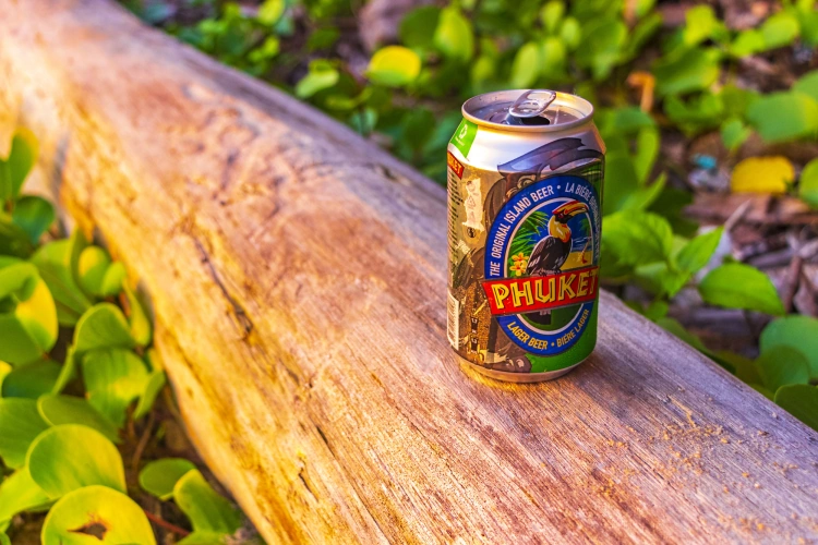 A Can Of Phuket Beer On A Log In Thailand