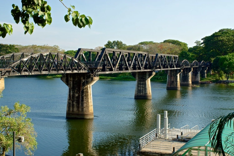 bridge over the river Kwai on a hot sunny day with trees in background